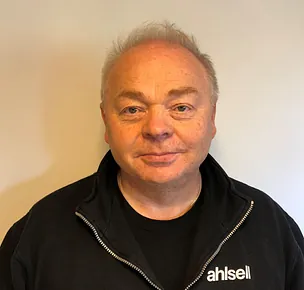 Mann med arbeidsklær og maskiner i bakgrunn